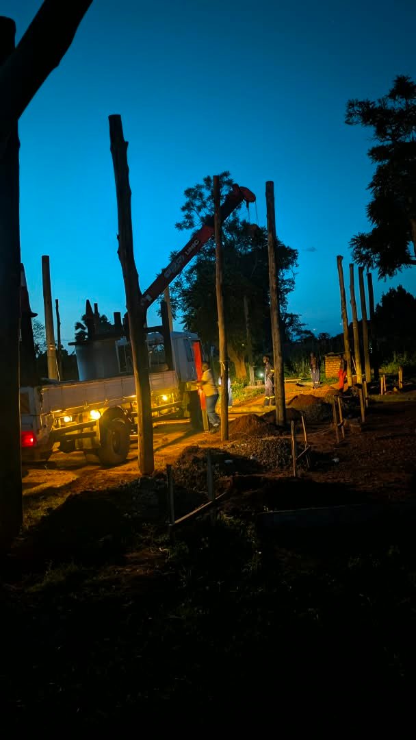 Utility poles being positioned with a crane truck